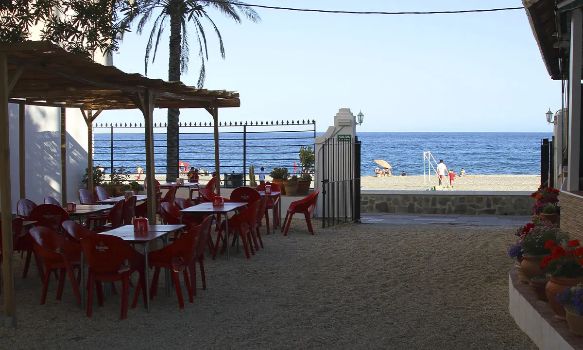 Terraza del chiringuito con la playa y el mar al fondo